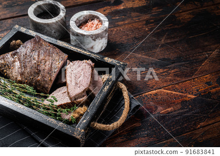 Grilled Tri Tip steak, sirloin bottom beef in a tray with herbs. Wooden background. Top view. Copy space Grilled Tri Tip steak, sirloin bottom beef in a tray with herbs. Wooden background. Top view. Copy space 91683841