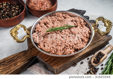 Uncooked vegan mince meat, raw plant based meat with thyme in skillet. White background. Top view 91683848