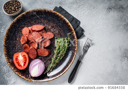 Fried sausage sucuk from beef meat on a plate with herbs. White background. Top view. Copy space Fried sausage sucuk from beef meat on a plate with herbs. White background. Top view. Copy space 91684338