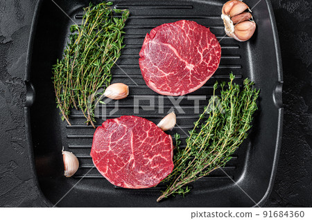 Tenderloin Raw Fillet Mignon beef steaks on a pan. Black background. Top view Tenderloin Raw Fillet Mignon beef steaks on a pan. Black background. Top view 91684360