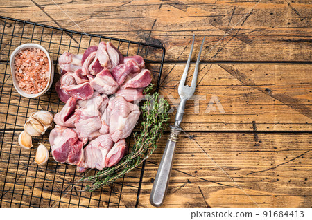 Fresh Raw chicken stomachs, gizzards on a grill ready for cooking with herbs. Wooden background. Top view. Copy space 91684413