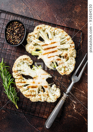 Grilled cauliflower steak with rosemary and spices, Vegan cuisine. Dark background. Top view 91684530