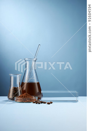 Front view of coffee decorated in transparent podium and glassware laboratory equipment light blue background 91684594