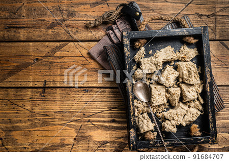 Turkish Halva with sunflower seeds and honey in wooden tray. Wooden background. Top view. Copy space 91684707