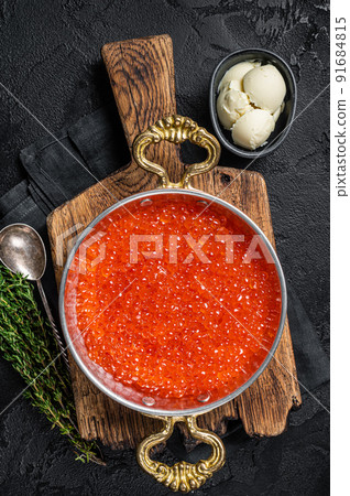 Red caviar in skillet on wooden board. Balck background. Top view Red caviar in skillet on wooden board. Balck background. Top view 91684815