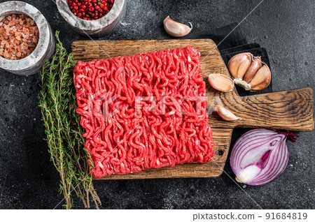 Raw Mince, minced Ground beef meat on a cutting board. Black background. Top view Raw Mince, minced Ground beef meat on a cutting board. Black background. Top view 91684819