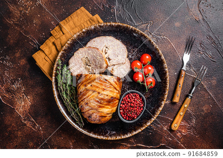 Baked delicious beef meatloaf, sliced meat loaf with bacon and herbs on a plate. Dark background. Top view Baked delicious beef meatloaf, sliced meat loaf with bacon and herbs on a plate. Dark background. Top view 91684859