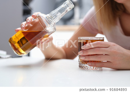 Woman drinks alcohol cognac or whiskey alone Woman drinks alcohol cognac or whiskey alone 91684893