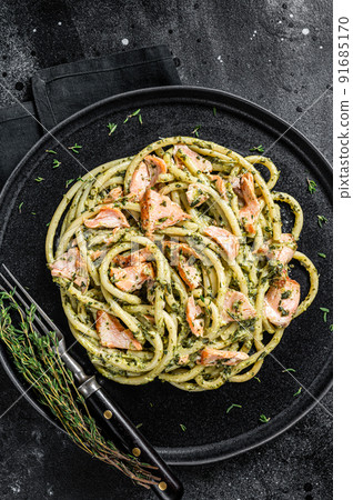 Bucatini Pasta with Smoked Salmon fillet and creamy spinach. Black background. Top view Bucatini Pasta with Smoked Salmon fillet and creamy spinach. Black background. Top view 91685170