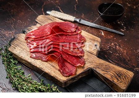 Turkish pastrami (kayseri pastirma), dried beef meat with spices. Dark background. Top view 91685199