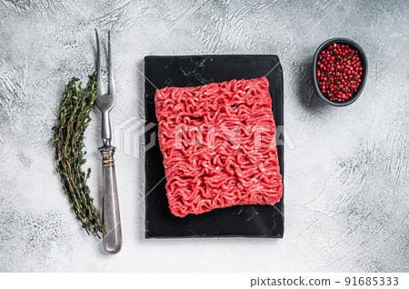 Raw mince Minced beef, ground meat with thyme and pepper. White background. Top view 91685333