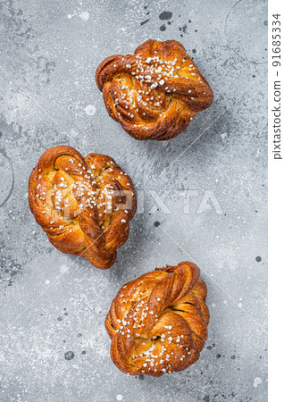 Swedish cinnamon buns Kanelbullar. Gray background. Top view Swedish cinnamon buns Kanelbullar. Gray background. Top view 91685334