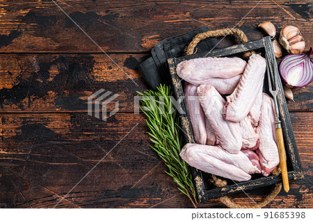 Fresh Raw duck and chicken wings in a tray. Dark wooden background. Top view. Copy space 91685398