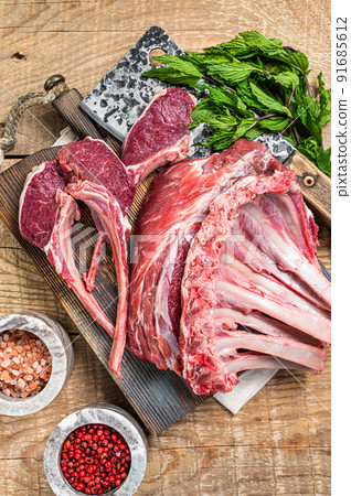 Raw Rack and rib chops of lamb, mutton on a butcher cutting board. Wooden background. Top view Raw Rack and rib chops of lamb, mutton on a butcher cutting board. Wooden background. Top view 91685612