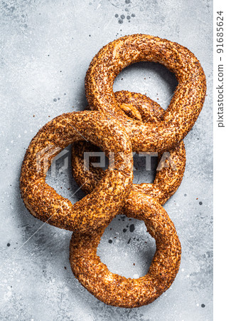 Turkish Bagel Simit with sesame traditional pastry. Gray background. Top view Turkish Bagel Simit with sesame traditional pastry. Gray background. Top view 91685624