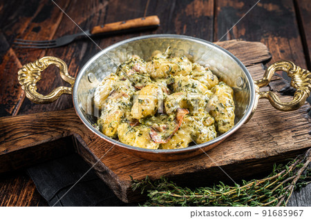 Italian Gnocchi potato pasta with spinach and parmesan in skillet. Wooden background. Top view 91685967