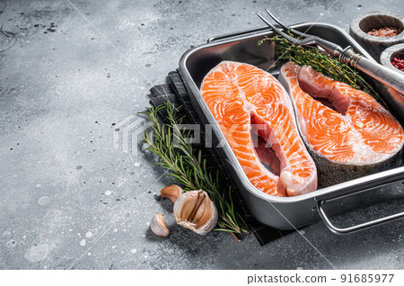 Raw Salmon Fish Steaks prepared for cooking with thyme and rosemary. Gray background. Top view. Copy space Raw Salmon Fish Steaks prepared for cooking with thyme and rosemary. Gray background. Top view. Copy space 91685977