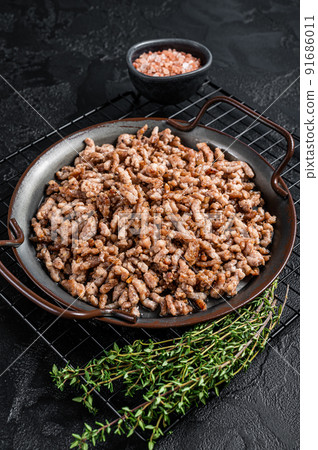 Fried mince beef and lamb meat in a tray with spices. Black background. Top view Fried mince beef and lamb meat in a tray with spices. Black background. Top view 91686011