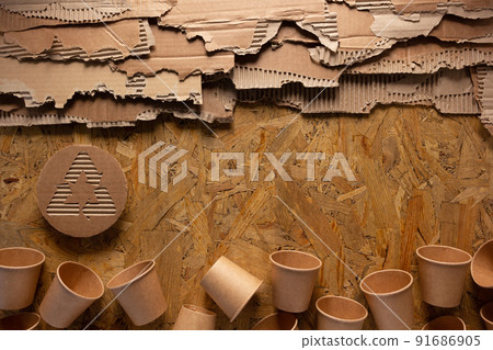 Cardboard torn edge on chipboard plywood background. Recycle symbol and product from recycled paper 91686905