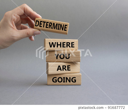 Determination symbol. Wooden blocks with words Determine where you are going. Beautiful grey background. Businessman hand. Business and Determine where you are going concept. Copy space 91687772