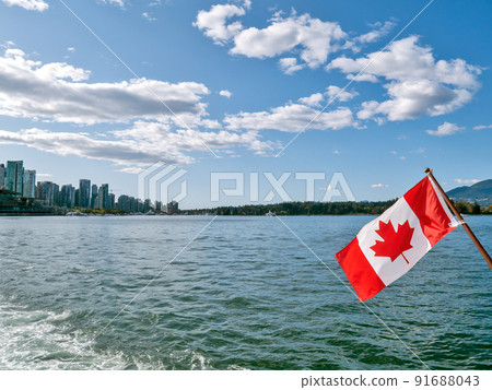 Canadian flag on blue sky and water background in Vancouver harbor 91688043