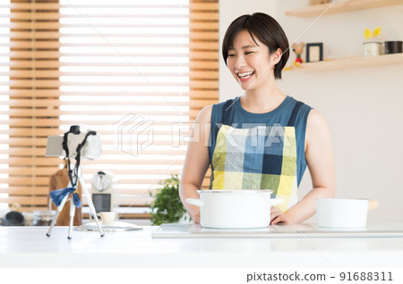 A woman recording a cooking video 91688311