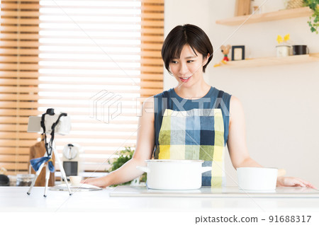 A woman recording a cooking video 91688317
