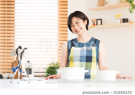 A woman recording a cooking video 91688320