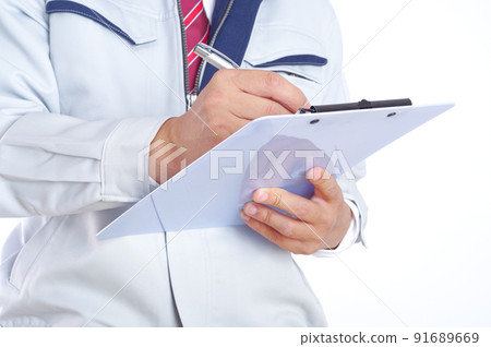 A man in work clothes filling out documents A man in work clothes filling out documents 91689669