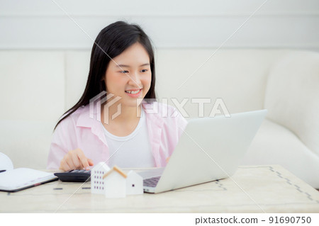 Young asian woman sitting and planning and calculate expense and mortgage with calculator and home. 91690750