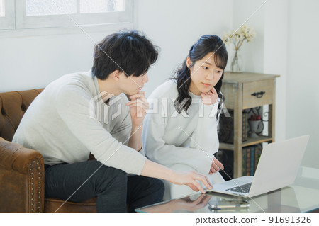 一對夫婦在客廳裡看電腦 一對夫婦在客廳裡看電腦 91691326