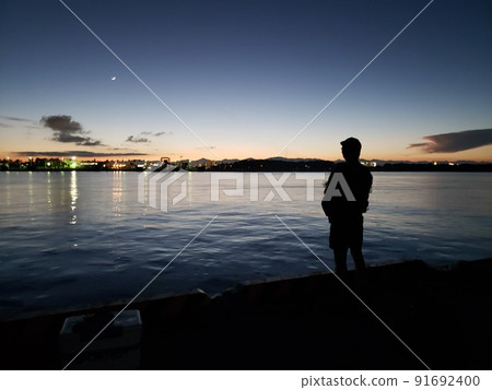 A man fishing in the early evening A man fishing in the early evening 91692400