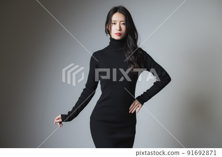 A woman in a black knit dress 91692871