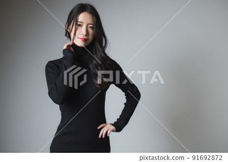 A woman in a black knit dress 91692872