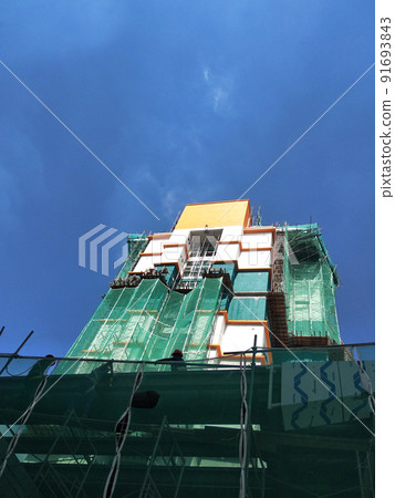 SELANGOR, MALAYSIA -JULY 16, 2018: Safety netting is installed at the high rise building exterior scaffolding during construction. Its avoid building object falling directly to the ground. SELANGOR, MALAYSIA -JULY 16, 2018: Safety netting is installed at the high rise building exterior scaffolding during construction. Its avoid building object falling directly to the ground. 91693843