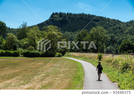 Woman walking along the Railway tracks towards Trier 91696375
