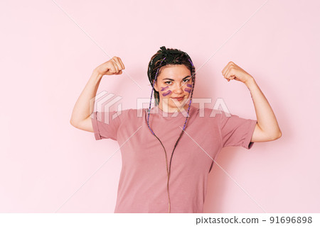 Girl with purple paint on her face shows strength 91696898