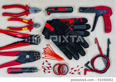 Red professional electrician tools on wood background. Top view. 91698002
