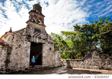Senior woman at the beautiful historical church La Ermita built in the sixteenth century in the town of Mariquita in Colombia 91698407