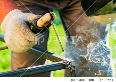 A bright flash of an electric arc between the electrode and the metal. A bright flash of an electric arc between the electrode and the metal. 91698664