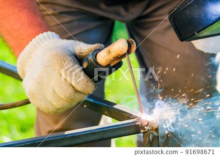 The arc welding electrode melts the metal. The arc welding electrode melts the metal. 91698671