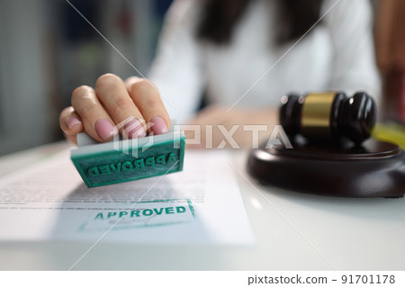Business woman puts an approved seal on a closeup of document 91701178