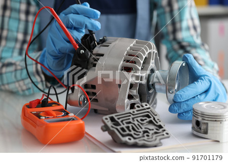 Automotive alternator repair test stator closeup with copper coil in workshop Automotive alternator repair test stator closeup with copper coil in workshop 91701179
