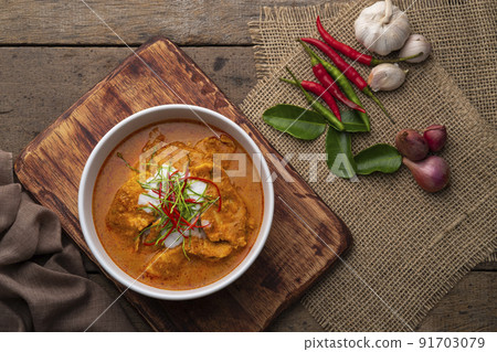 Panaeng Curry with chicken.Sliced chicken breast Meat in red curry paste and coconut milk,topping with coconut cream and Shredded kaffir lime leaves.Thai style food.Top view Panaeng Curry with chicken.Sliced chicken breast Meat in red curry paste and coconut milk,topping with coconut cream and Shredded kaffir lime leaves.Thai style food.Top view 91703079