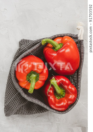 Fresh organic ripe sweet red bell pepper in eco-friendly reusable produce bag on gray, copy space Fresh organic ripe sweet red bell pepper in eco-friendly reusable produce bag on gray, copy space 91703592