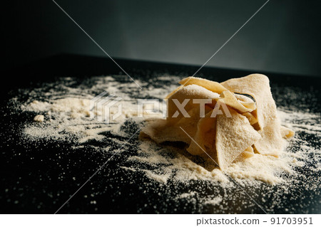 Pasta and flour on black table from italian restaurant Pasta and flour on black table from italian restaurant 91703951