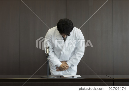 Male doctor in white coat giving an apology press conference 91704474