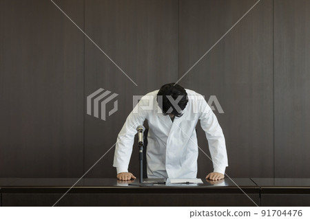 Male doctor in white coat giving an apology press conference 91704476