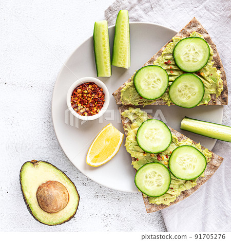 Crisp bread sandwiches with mashed avocado and cucumber 91705276