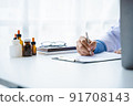 Close-up of doctor's hands writing prescription with bottle with pills. Healthcare, medical and pharmacy concept. 91708143